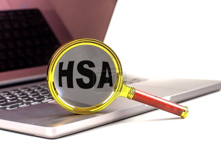 HSA-Wort auf Lupe am Laptop, weißer Hintergrund . 