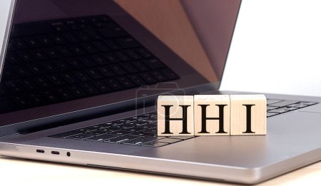 Mot HHI sur un bloc de bois sur ordinateur portable, concept d'entreprise. 