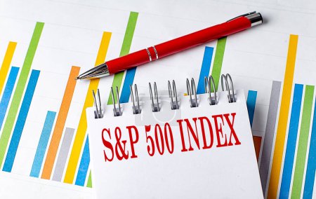 S AND P 500 INDEX text on a notebook on chart with pen . 