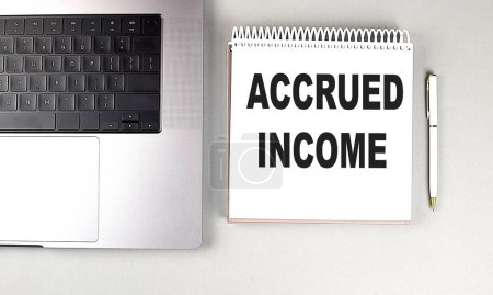 Photo for ACCRUED INCOME text on a notebook with laptop and pen . - Royalty Free Image