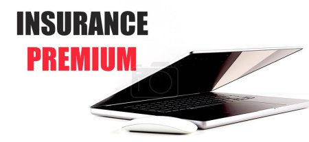 INSURANCE PREMIUM text on a white background with laptop and mouse . 