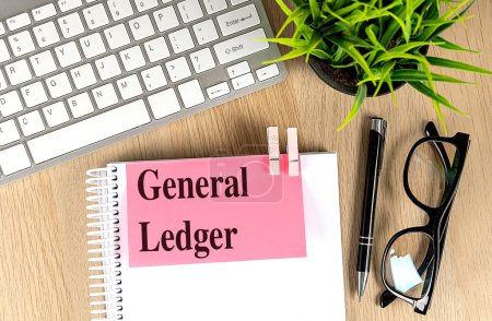 GENERAL LEDGER text pink sticky on a notebook with keyboard, pen and glasses . 