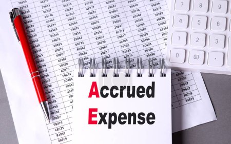 ACCRUED EXPENSE text on a notebook with chart , pen and calculator 