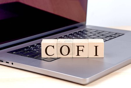 COFI palabra en un bloque de madera en el ordenador portátil, concepto de negocio. 