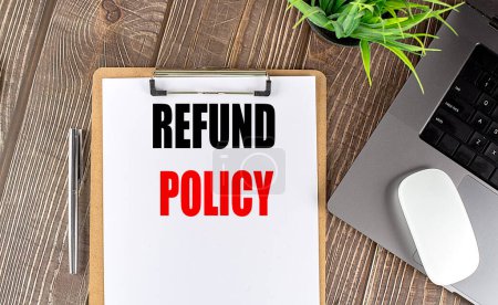 Photo for REFUND POLICY text on a clipboard paper with laptop, mouse and pen . - Royalty Free Image