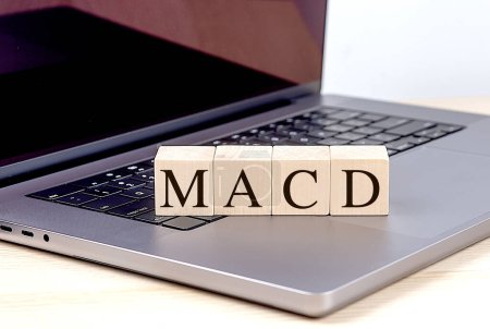 MACD-Wort auf einem Holzklotz am Laptop, Geschäftskonzept. 