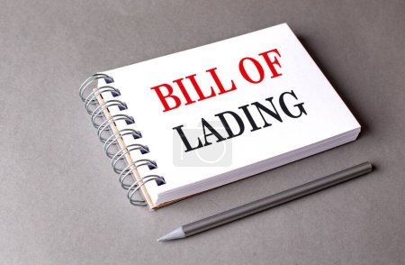BILL OF LADING text on a notebook on grey background . 