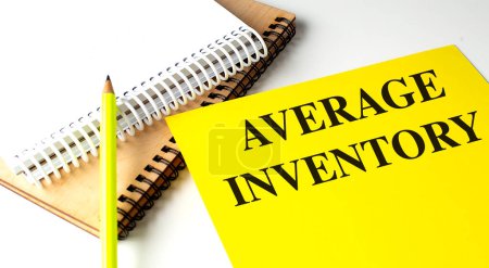 AVERAGE INVENTORY text on a yellow paper with notebooks. 