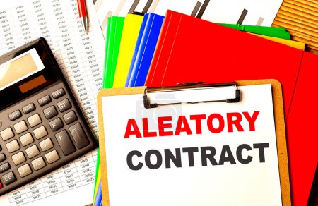 ALEATORY CONTRACT text on a clipboard with calculator and color folder . 