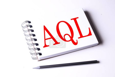 AQL word on a notebook on white background . 