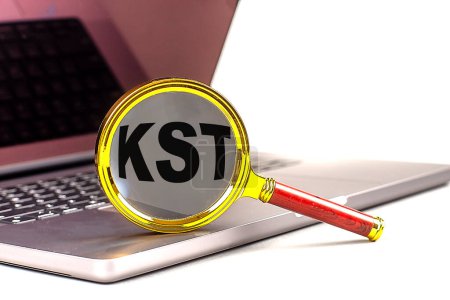 KST-Wort auf Lupe am Laptop, weißer Hintergrund . 