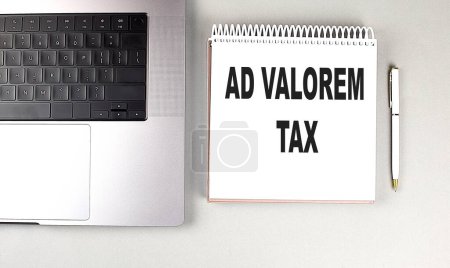 AD VALOREM TAX text on a notebook with laptop and pen . 
