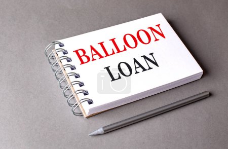 BALLOON LOAN text on a notebook on grey background . 