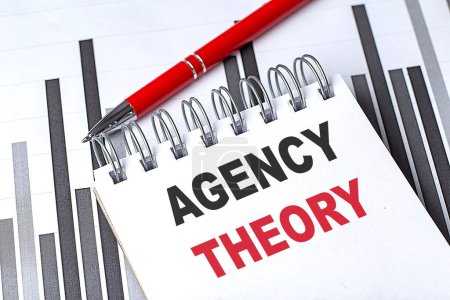 AGENCY THEORY ext on notebook on a chart with pen . 