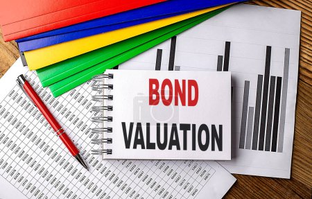 BOND VALUATION text on a notebook with folder on chart. 