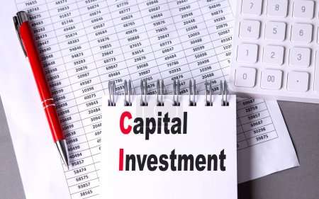 CAPITAL INVESTMENT text on a notebook with chart , pen and calculator. 