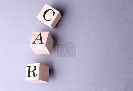 CAR word on a wooden block on gray background 