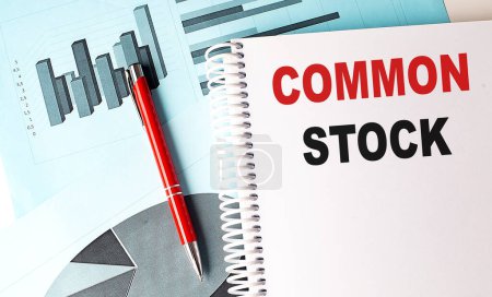 COMMON STOCK text on a notebook on chart background . 