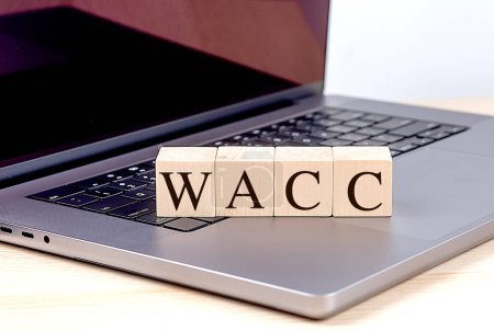 Foto de WACC palabra en un bloque de madera en un ordenador portátil, concepto de negocio. - Imagen libre de derechos