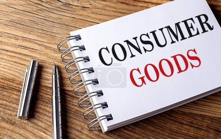 CONSUMER GOODS text on a notebook on wooden background 