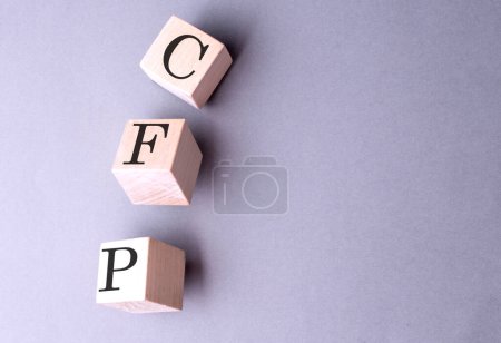 Palabra CFP sobre un bloque de madera sobre fondo gris 