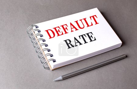 DEFAULT RATE text on a notebook on grey background 