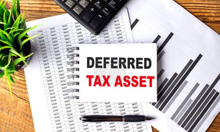 DEFERRED TAX ASSET text on a notebook on chart with calculator and pen . 