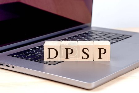 Palabra DPSP en un bloque de madera en un ordenador portátil, concepto de negocio. 