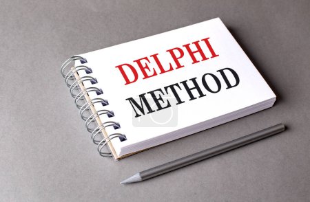 DELPHI METOD text on a notebook on grey background 