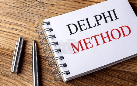 DELPHI METOD text on a notebook on wooden background . 