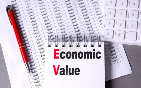 ECONOMIC VALUE text on a notebook with chart , pen and calculator. 