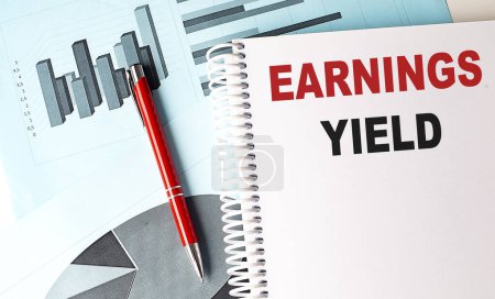 EARNINGS YIELD text on a notebook on chart background 