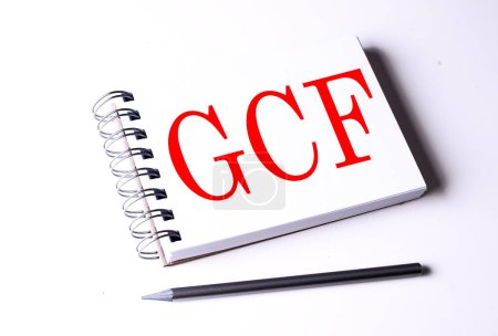 Palabra del GCF en un cuaderno sobre fondo blanco 