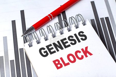 GENESIS BLOCK text on a notebook on chart with pen . 