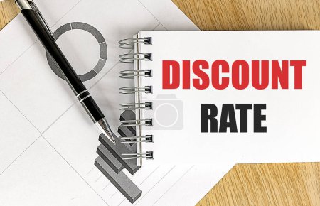 DISCOUNT RATE text on a notebook with chart on wooden background. 