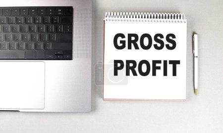 GROSS PROFIT text on a notebook with laptop and pen . 