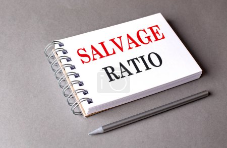 SALVAGE RATIO Text auf einem Notizbuch auf grauem Hintergrund 
