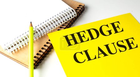 HEDGE CLAUSE text on a yellow paper with notebooks. 