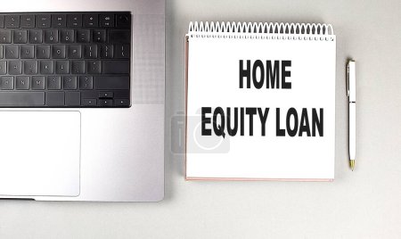 HOME EQUITY LOAN text on a notebook with laptop and pen . 