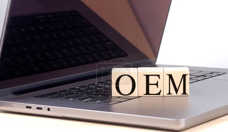 OEM-Wort auf einem Holzblock auf einem Laptop, Geschäftskonzept. 
