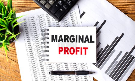 MARGINAL PROFIT text on notebook on a chart with calculator and pen . 
