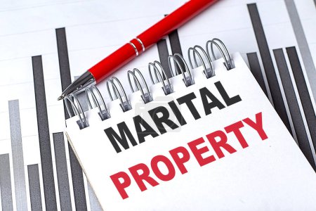 MARITAL PROPERTY text on a notebook on chart with pen . 