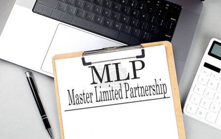 MLP-Wort auf Zwischenablage am Laptop mit Taschenrechner und Stift . 