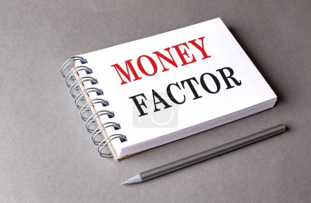 Photo for MONEY FACTOR text on a notebook on grey background . - Royalty Free Image
