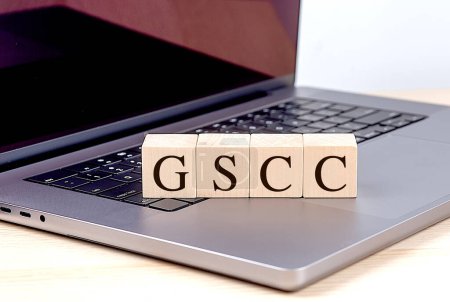 Foto de Palabra GSCC en bloque de madera en el ordenador portátil, concepto de negocio. - Imagen libre de derechos