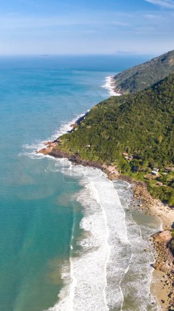 Photo for Coastline with beach, mountains and blue ocean with waves in Brazil. Aerial view of Saquinho beach. Florianopolis Santa Catarina. SC - Royalty Free Image