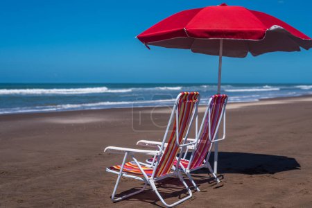 Foto de Conjunto de dos sillas de playa con sombrilla en la playa en un día de verano. Concepto de verano. - Imagen libre de derechos