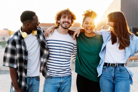 Téléchargez les photos : Groupe de jeunes amis profitant de bons moments et s'amusant ensemble à l'extérieur dans la ville au coucher du soleil - Portrait de jeunesse - en image libre de droit