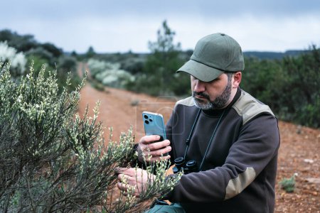 Ökologe Park Ranger arbeitet im Nationalpark Reserve Überwachung der Pflanzengesundheit mit mobiler App