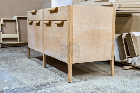 Chest of drawers made of solid alder in process of production at workshop. Creation of modern domestic furniture for bedroom interior